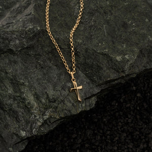 The 14K Gold Tiny Cross Necklace for Men showcases a small, polished cross pendant gracefully centered on a chain of fine, uniform links. This piece of religious jewelry offers a simple and elegant look, ideal for those seeking understated men's gold cross necklaces.