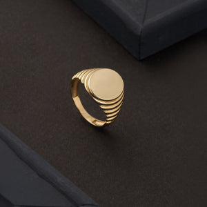 The 14K Solid Gold Watch Style Fancy Signet Ring for Men features a sleek, round, smooth top and a ribbed design on the sides, adding a contemporary and elegant touch. Ideal for men's jewelry aficionados, this engraved signet ring is set against a plain white background, allowing its polished finish to truly shine.