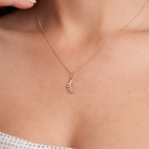 The 14K Solid Gold Dainty Leaf Necklace by RundaJewelryUs features a delicate leafy branch pendant on a fine chain. This handmade jewelry piece highlights small, smooth leaves extending from a central stem, offering an elegant and minimalist design against a plain white background.