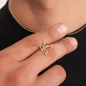 A 14K solid gold bird necklace featuring a geometric hummingbird pendant on an elegant chain. This origami freedom symbol necklace is crafted with clean lines and minimalist style, making it ideal for those who appreciate animal-inspired jewelry.