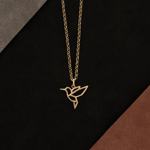 A 14K solid gold bird necklace featuring a geometric hummingbird pendant on an elegant chain. This origami freedom symbol necklace is crafted with clean lines and minimalist style, making it ideal for those who appreciate animal-inspired jewelry.