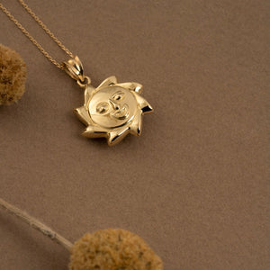 This exquisite piece from RundaJewelryUs is the 14K Gold Sun Necklace, showcasing a pendant with a cheerful face at its core and encircled by radiant pointed rays.