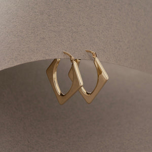 A pair of 14K Real Gold Triangle Geometric Hoop Earrings from RundaJewelryUs is displayed. One earring shows the front view with a hinged clasp, while the other reveals the side view, emphasizing the earrings' sleek design that adds an elegant touch to any outfit.