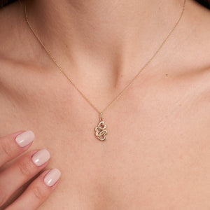 The 14K Solid Gold Trio Heart Pendant Necklace by RundaJewelryUs is crafted in 14K yellow gold and features a pendant with three interlocking heart shapes. The elegant design is suspended from a delicate chain, highlighting the shiny gold finish with a commitment to sustainable methods.