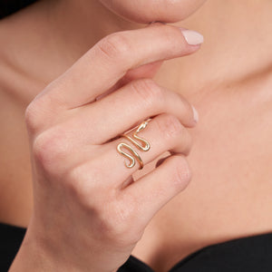 The 14K Solid Gold Snake Ring is an exquisite piece crafted in the shape of a handmade serpent with a sleek, curving form and tiny gemstone eyes, providing a sophisticated and elegant appearance. Discover the charm of authentic gold jewelry in this enchanting design.