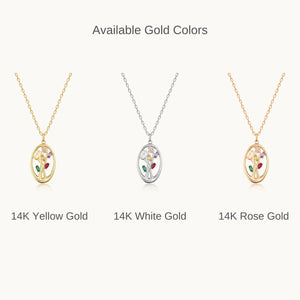 The 14K Solid Gold Birthstone Tree Pendant Necklace features a gorgeous pendant with an abstract tree design. It is set against a plain white background and showcases branches enhanced with multicolored gemstones in green, red, and purple, all enclosed within an oval frame.