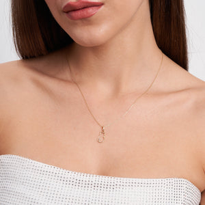 Discover the 14K Solid Gold Cat Necklace, a must-have for cat enthusiasts and summer jewelry collections. Its elegant chain displays a cat outline pendant adorned with a small gemstone at the tip of the tail, all set against a white background.