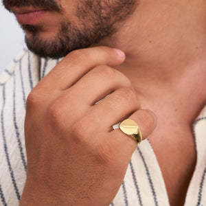 The 14K Solid Gold Matte & Polished Signet Ring for Men showcases a sophisticated design with its flat, oval-shaped face featuring a unique matte and shiny half-and-half finish. The engraved signet ring boasts a smooth band and minimalist elegance, creating an exquisite piece of men's jewelry.