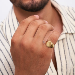 The 14K Solid Gold Matte & Polished Oval Signet Ring for Men features a flat, smooth oval-shaped top set against a plain white background. This engraved ring embodies timeless elegance and sophistication, making it a perfect choice for men's jewelry.